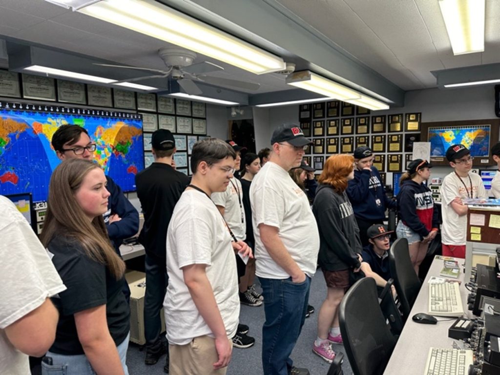 group of teenagers in a large ham radio station
