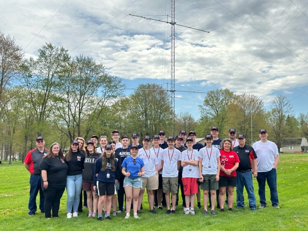 group of teenagers near a large ham radio antenna