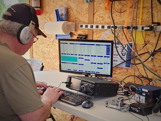 ham radio operator typing on a keyboard in a portble station