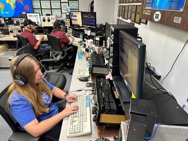 ham radio operators working at keyboards at large station