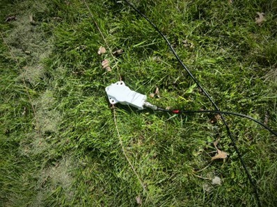 homemade dipole antenna resting on grass