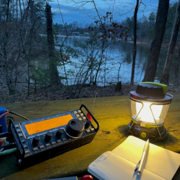 small portable ham radio station near a wooded lake shore