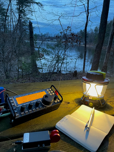 small portable ham radio station near a wooded lake shore