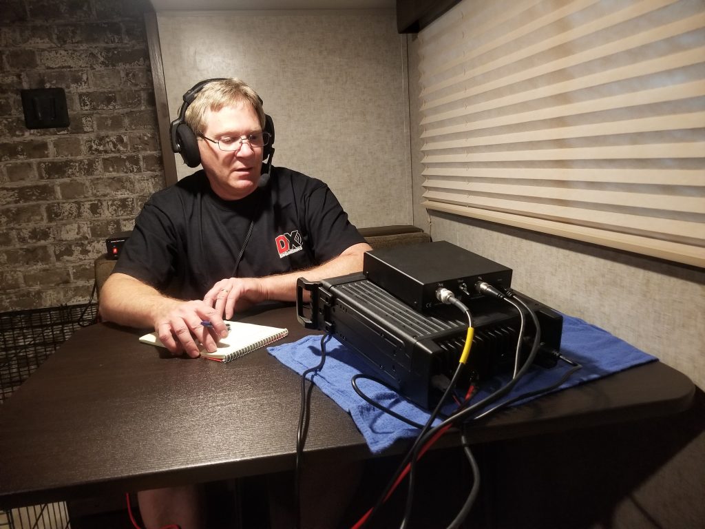 man working at small portable ham radio station