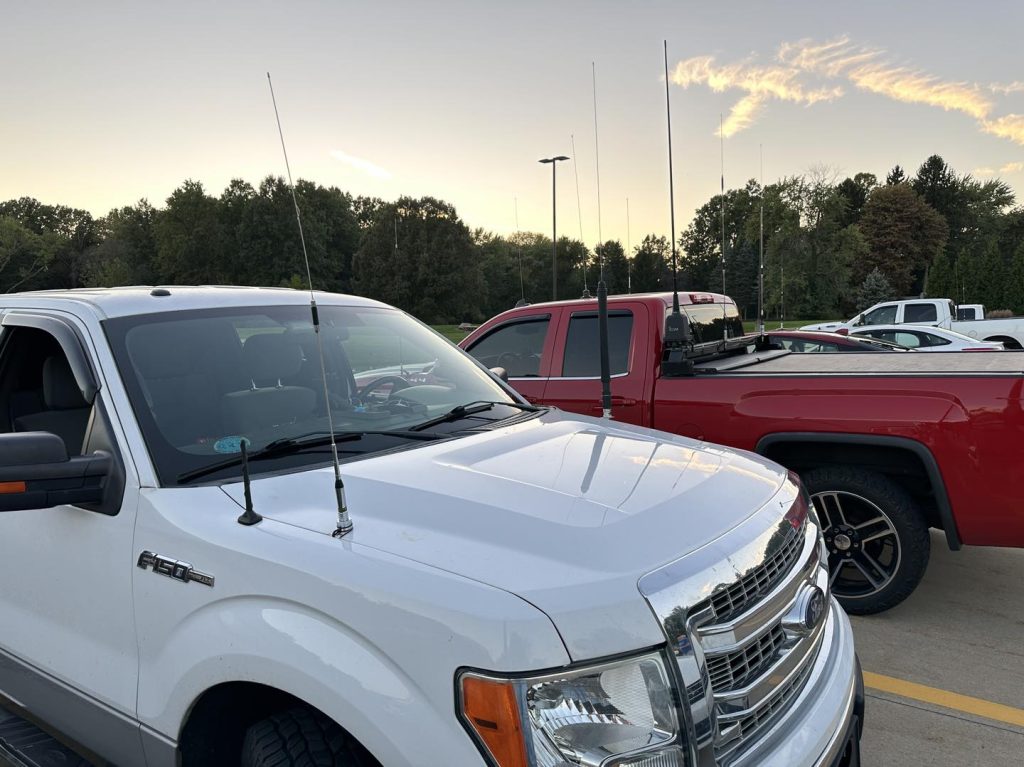 trucks parked with several mobile ham antennas installed