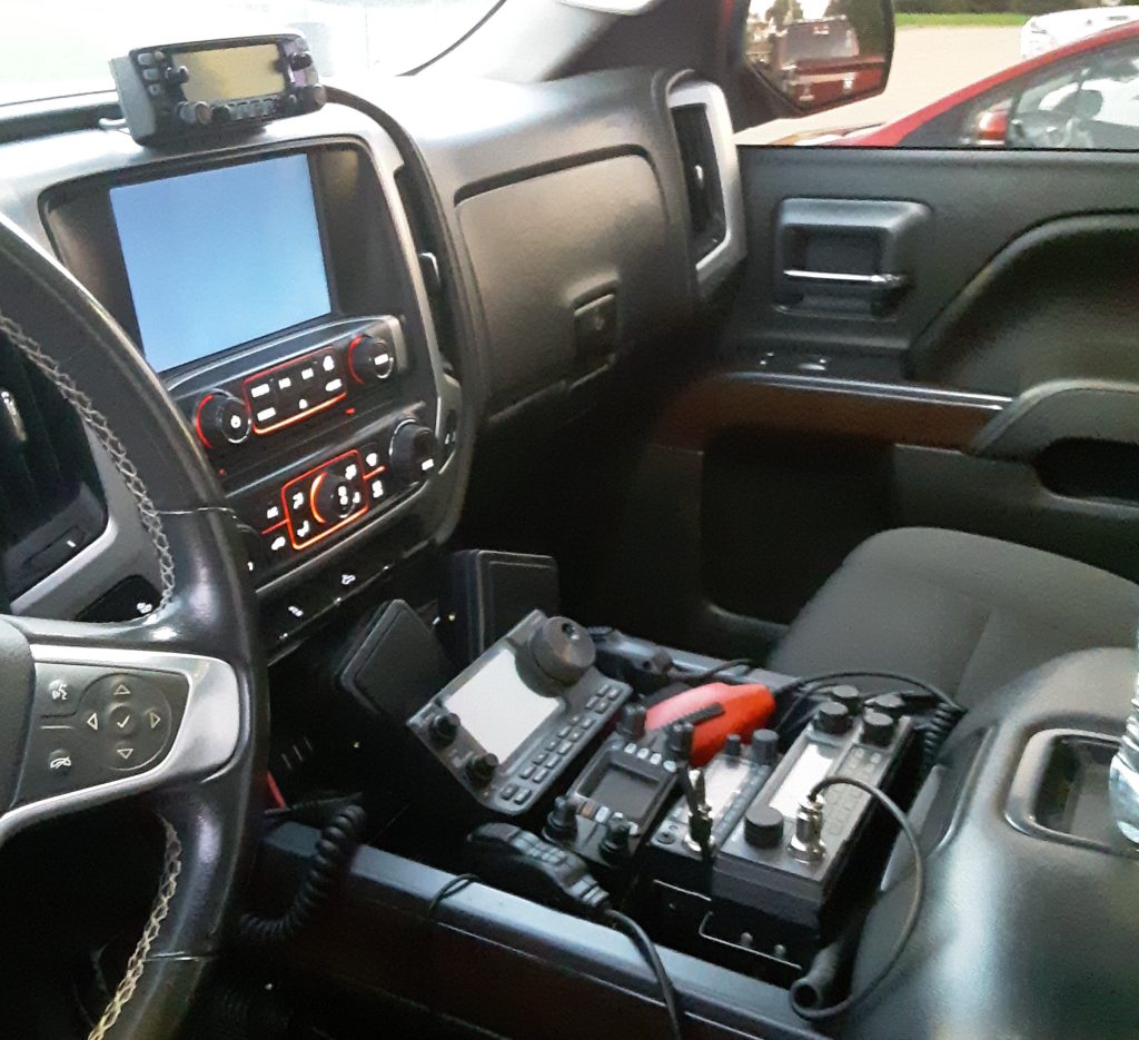 several ham radio transceivers installed in a vehicle console