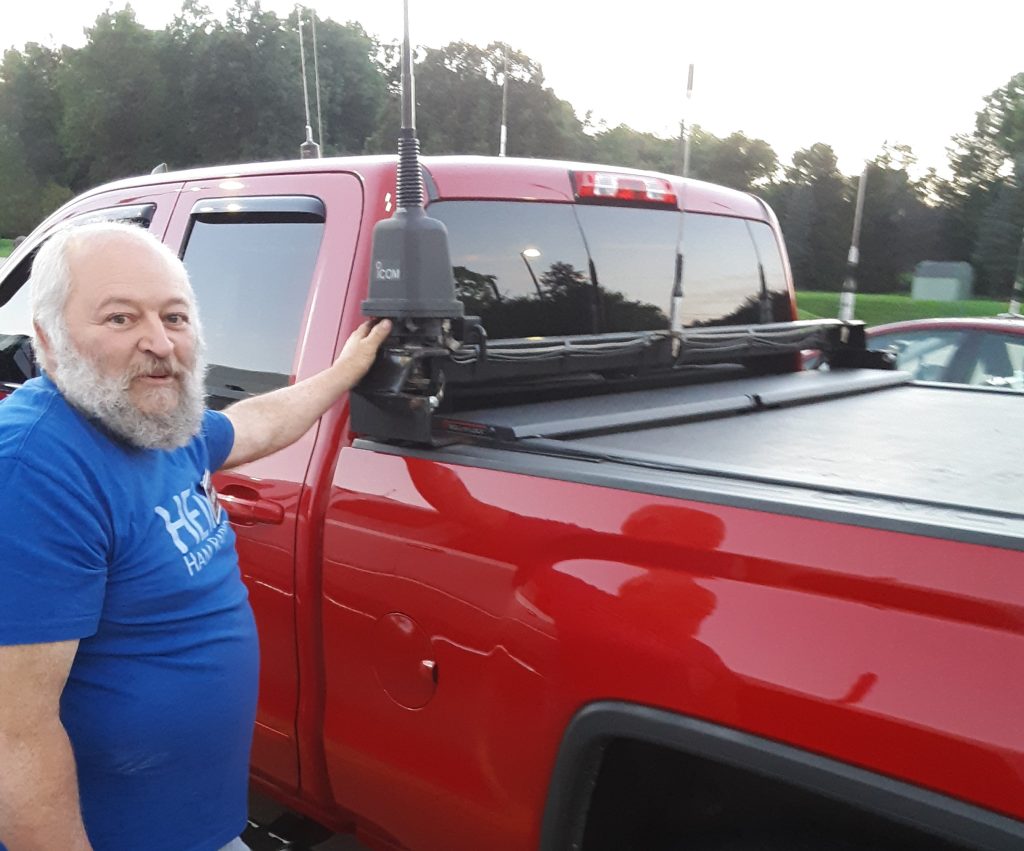 man standing near truck with ham radio antennas