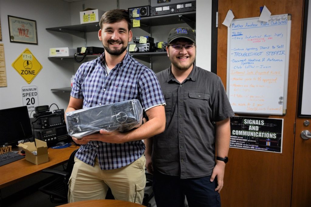 two young men with a new ham radio transceiver