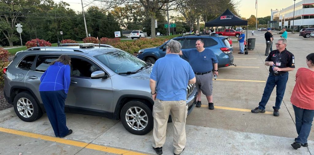 group meeting around an SUV with ham radio antennas