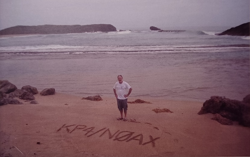 old photo of man standing on beach