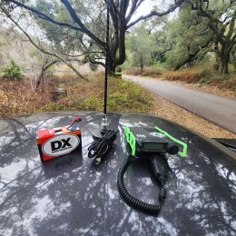 Ham radio and antenna resting on the roof of a car