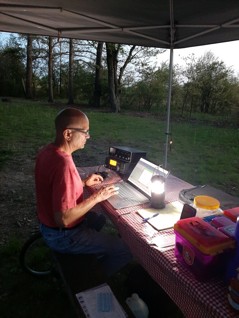 man working at outdoor portable ham radio station