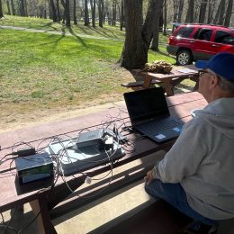 man sitting at an outdoor portable ham station