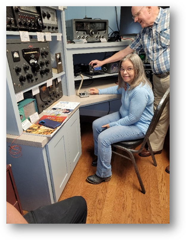 operator sitting at museum ham radio shack desk